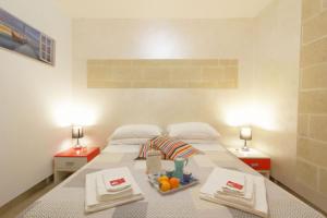Un dormitorio con una cama con una bandeja de fruta. en White Suite B&B, en Lecce