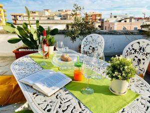un tavolo con un libro e bicchieri da vino sul balcone di A DUE PASSI temporary apartment a Trani