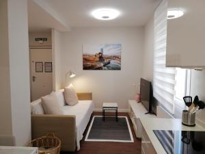 a living room with a bed and a tv at Kaixo-San Mames-Bilbao Intermodal in Bilbao