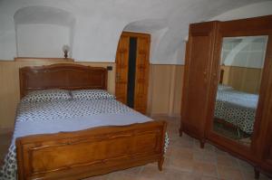 - une chambre avec un lit en bois et un miroir dans l'établissement Il Poietto, à Borgone Susa