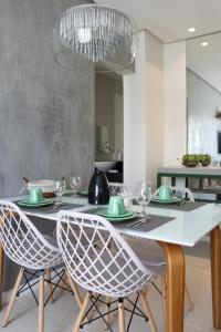a dining room with a table with chairs and a chandelier at FANTÁSTICO APARTAMENTO NA BARRA in Salvador
