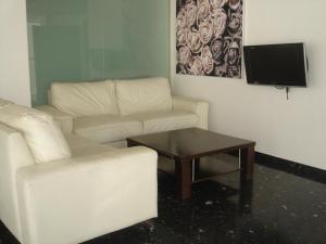 a living room with a white couch and a coffee table at Hotel Lluna in Alzira