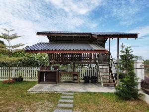 a gazebo with a table and a ladder at Orchard Villa Melaka in Malacca