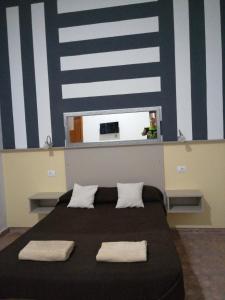 een slaapkamer met een zwart bed en 2 witte kussens bij Apartmento KA Sánchez in Vecindario