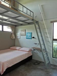 ein Schlafzimmer mit einem Etagenbett und einer Treppe in der Unterkunft Orchard Villa Melaka in Malakka