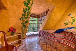 a bedroom with a bed and a window at El Sano Banano Beachside Hotel in Montezuma