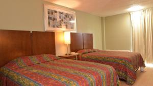 Postel nebo postele na pokoji v ubytování Red Carpet Inn