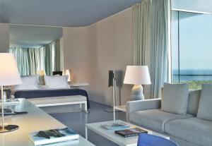 une chambre d'hôtel avec un lit et un canapé dans l'établissement The Oitavos, à Cascais