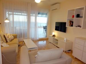 - un salon avec un canapé et une télévision dans l'établissement Gran terraza con espectaculares vistas al mar, à Cap de Palos