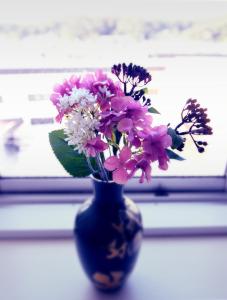 a blue vase filled with pink and white flowers at Guest room Kamakura Nagomi -Hydrangea- in Kamakura