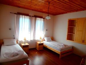 um quarto com 2 camas, uma janela e 2 candeeiros em Hotel Mitnitsa and TKZS Biliantsi em Arda