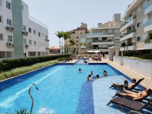 - un groupe de personnes dans la piscine d'un complexe dans l'établissement Apartamento Moderno na Praia dos Ingleses, à Florianópolis