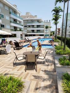 a group of people playing in a swimming pool at Apartamento Moderno na Praia dos Ingleses in Florianópolis