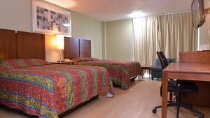 Postel nebo postele na pokoji v ubytování Red Carpet Inn