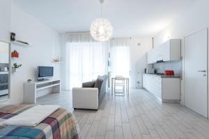 a white room with a bed and a kitchen at Casa Giovanni in Bergamo