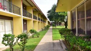 an empty sidewalk in front of a building at Red Carpet Inn in Houston