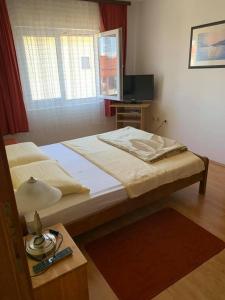 - une chambre avec deux lits et une table avec une lampe dans l'établissement Apartments Anna - peaceful and quiet, à Batalaži