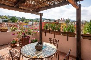 サンミゲル・デ・アジェンデにあるCozy 1 Bedroom suite @ the best of San Miguel (R3)の植物のあるバルコニー(テーブル、椅子付)