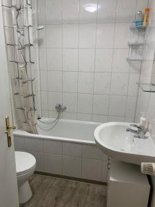 a bathroom with a toilet and a tub and a sink at Feuerbachstr.9 Ferienwohnung in Bottrop