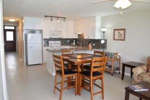 a kitchen and living room with a table and chairs at Hale Kai O'Kihei 305 in Kihei