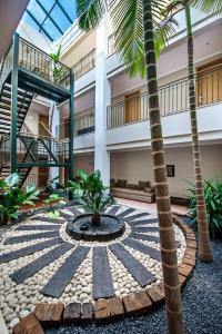 a courtyard with a fountain and palm trees in a building at Vale d'El Rei Hotel & Villas in Carvoeiro