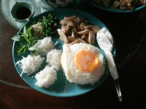 um prato azul de comida com ovo e arroz em ต้งโฮมหละปูน ณ ตูบคำ em Lamphun