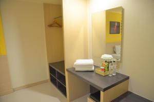 a bathroom with a mirror and a table with towels at Venice Palace Hotel in Sungai Kolok