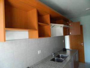 una cocina con fregadero y armarios de madera en DEPARTAMENTO ENTERO CORDOBA CERCA DEL KEMPES/CIRCUNVALACION en Córdoba