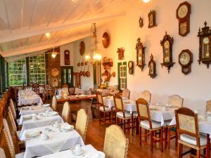 a restaurant with tables and chairs and clocks on the walls at Pousada da Marquesa in Paraty