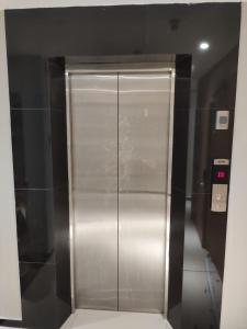 a metal elevator in a building with a hallway at Hotel 99 Seri Kembangan Serdang in Seri Kembangan