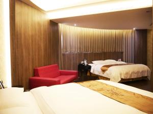 um quarto de hotel com duas camas e uma cadeira vermelha em Refinement Motel em Taichung