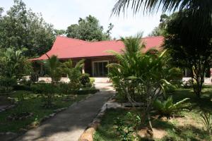 a house with a red roof and a garden at Balai Serama Guesthouse in Kuala Tahan