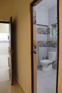 a bathroom with a toilet and a glass door at Grand Suites Srirangam in Tiruchchirāppalli