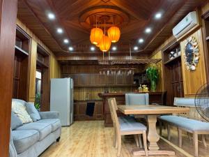a living room with a table and a kitchen at Khamy Riverside Villa in Hoi An
