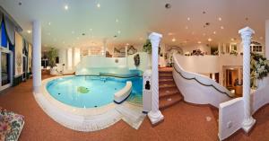 a large indoor pool with a slide in a house at Genuss - und Vitalhotel Moisl in Abtenau