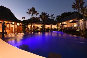 - une grande piscine en face d'une maison la nuit dans l'établissement LGood Lembongan Island Villas, à Nusa Lembongan