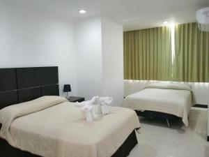 - une chambre d'hôtel avec 2 lits et des serviettes dans l'établissement Hotel Plaza Playa, à Playa del Carmen