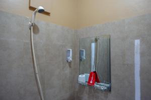 a shower in a bathroom with a shower head at RedDoorz Plus Syariah @ Hotel Boulevard Luwuk in Luwuk +36 photos