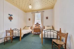 a bedroom with two beds and a window at Comstock Cottage Welcomes You in Queenstown