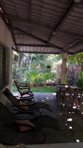 een patio met een tafel en stoelen en een bank bij Hostal El Balsamo in El Sunzal