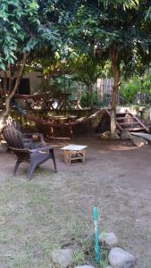 einen Park mit einer Hängematte, einer Bank und einem Tisch in der Unterkunft Hostal El Balsamo in El Sunzal