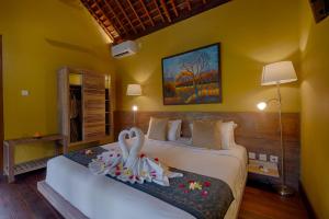 una camera con due letti in una stanza con pareti gialle di Samkhya Villas - CHSE Certified ad Ubud