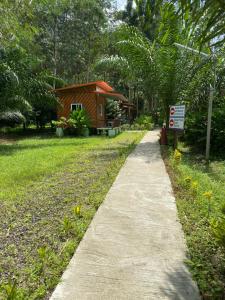 einen Weg, der zu einem kleinen Gebäude mit einem Schild führt in der Unterkunft Khaosok Bamboo Huts Resort in Khao Sok