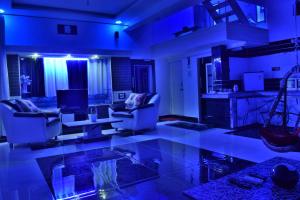 - un salon avec un éclairage bleu, un canapé et des chaises dans l'établissement Kabirbnb, à Chittorgarh