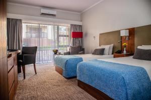 ブランタイヤにあるMalawi Sun Hotel & Conference Centreのベッドが2つと窓があるホテルの部屋 +43枚の写真