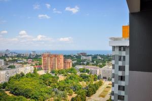 uitzicht op een stad met gebouwen en bomen bij ЛОФТ НА 26 ЭТАЖЕ in Odessa