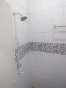 baño con ducha y puerta de cristal en skyz hostel en Padang