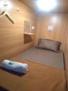 a small bedroom with a bed in a small room at skyz hostel in Padang