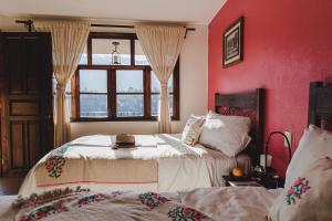 a red bedroom with two beds and a window at Hotel San Jorge in Tlatlauquitepec