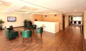 a lobby with green chairs and a waiting room at SFS Homebridge @ City in Trivandrum